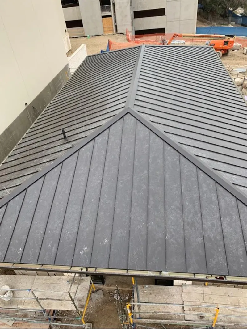 Commercial metal roof construction with crane equipment in Rancho Cucamonga